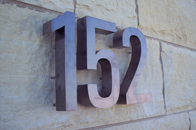 Bronze numbers on brick wall