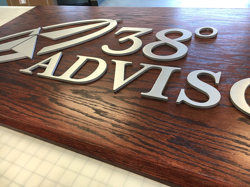 Wooden panel with raised metal logo 