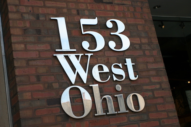 Steel numbers against a red brick background.